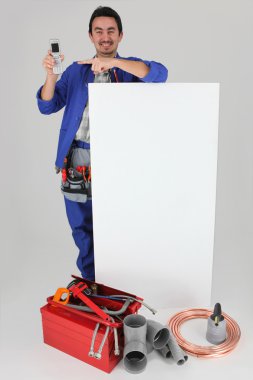 Handyman with many tools showing a cell phone clipart