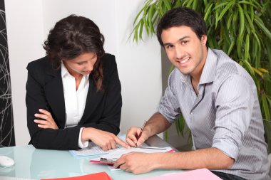 Young man signing a document clipart