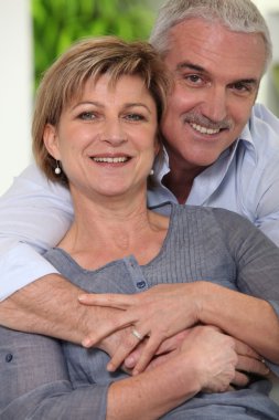 Mature married couple in a loving embrace clipart