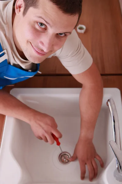 Un idraulico che fissa un lavandino — Foto Stock