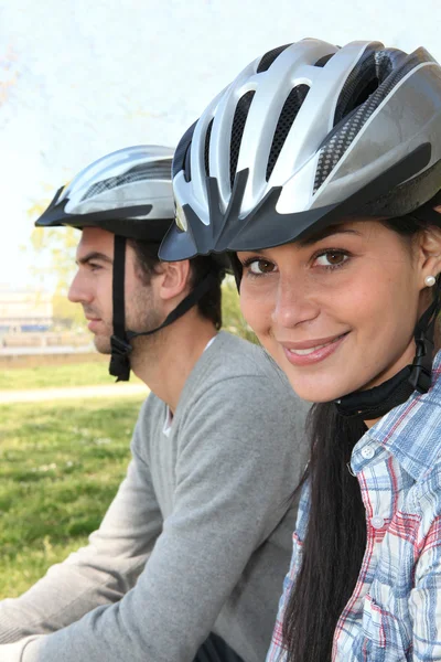 Casal jovem usando capacetes ciclo — Fotografia de Stock