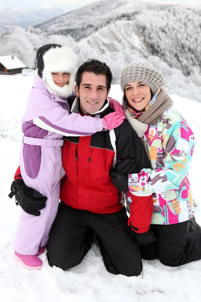 Young family on a snowy mountain — Stock Photo, Image