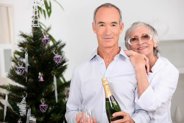 在圣诞节喝香槟的老年夫妇 — 图库照片