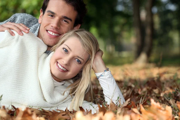 Mladý pár spolu leží na trávě — Stock fotografie