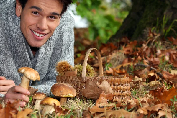 Mann sammelt Pilze und Kastanien im Wald — Stockfoto