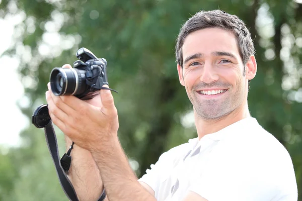 Homem tirando uma foto com uma câmera DSLR — Fotografia de Stock