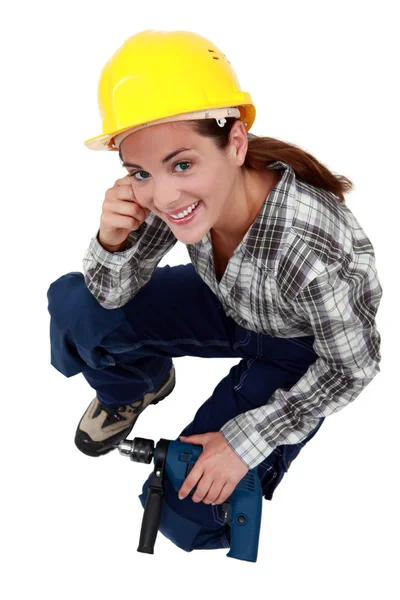En kvinnlig byggnadsarbetare med en borr. — Stockfoto