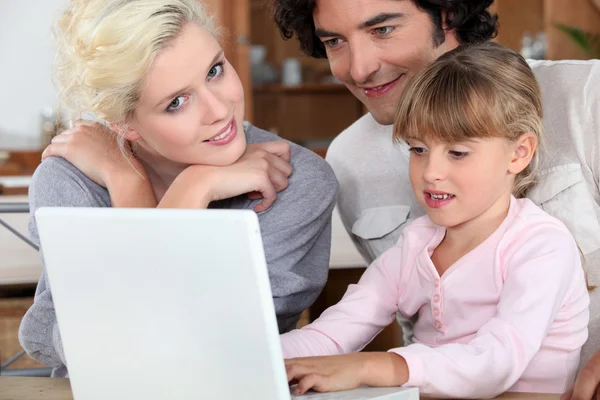 Couple with their daughter and a laptop — Stock Photo, Image