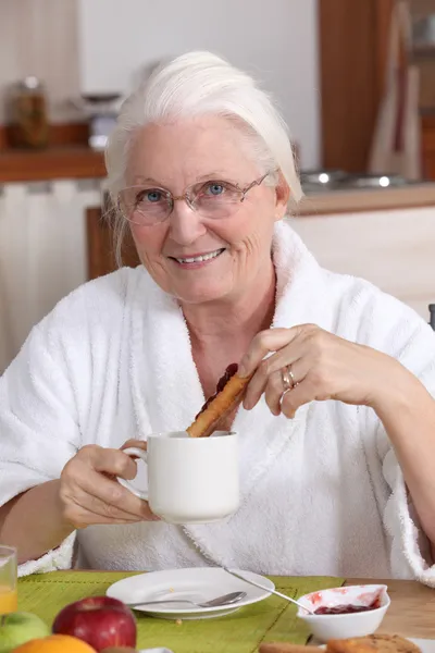 Elderly woman having breakfast — Stock Photo, Image