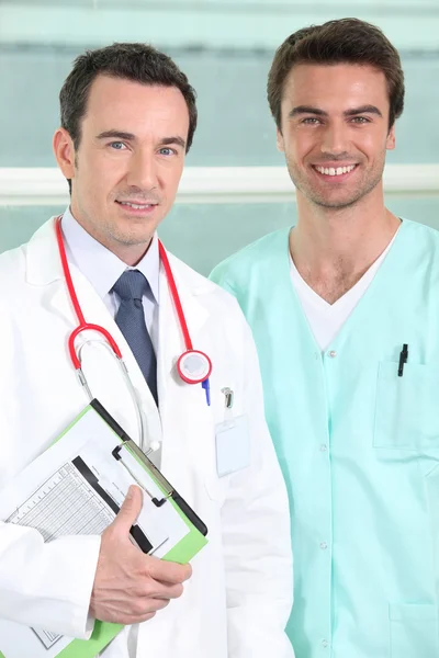 Mężczyzna lekarz i pielęgniarka ze schowka — Zdjęcie stockowe