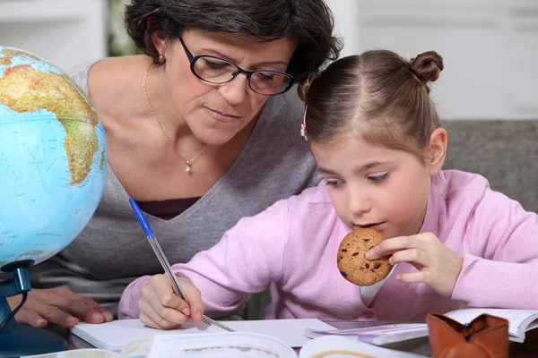 Mother helping her daughter with her homework. Stock Photo