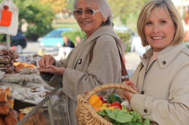 Mother and daughter shopping at the market together clipart