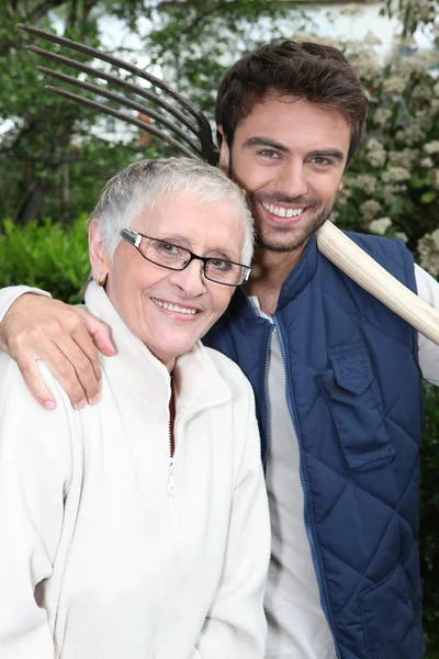 Genç adam yaşlı kadın ile Bahçe — Stok fotoğraf