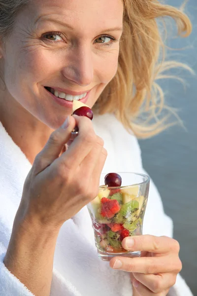 Mulher idosa comendo salada de frutas — Fotografia de Stock