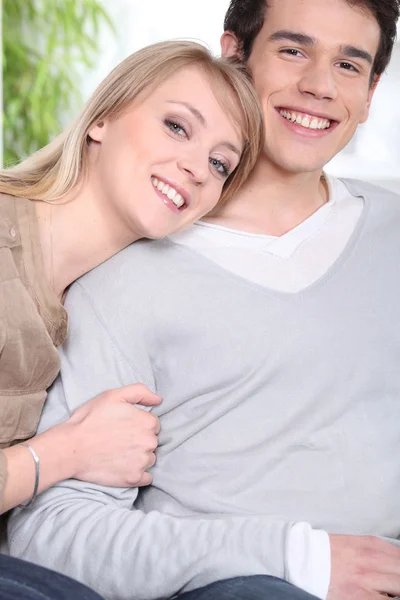 Glückliches junges Paar sitzt drinnen — Stockfoto