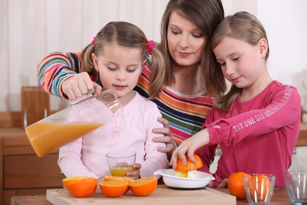 Família espremendo suco de laranja fresco — Fotografia de Stock