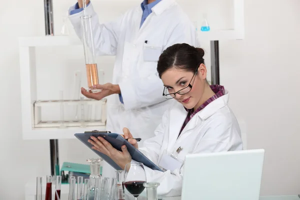 Женщина делает заметки в своей лаборатории . — стоковое фото