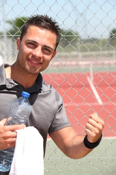 Jogador de tênis masculino com garrafa de água e toalha — Fotografia de Stock