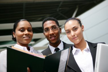 Low angle shot of young colored trio in office clipart