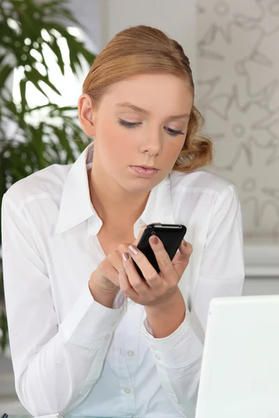 Giovane donna dai capelli biondi che invia SMS — Foto Stock