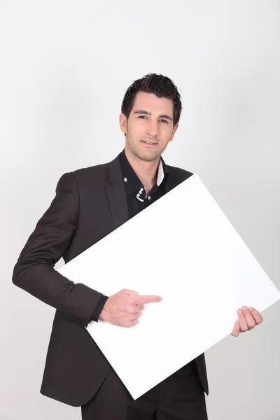 Man pointing to a blank sign — Stock Photo, Image