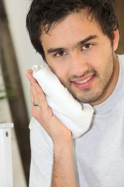 Ung man att trycka på en handduk att hans ansikte — Stockfoto