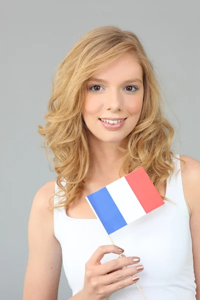 Pretty young woman holding a French flag — Stock Photo, Image