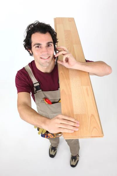 Trabalhador manual transportando prancha de madeira — Fotografia de Stock