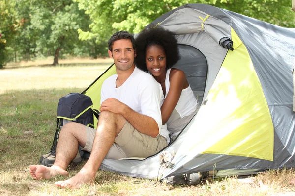 Happy couple sat by entrance to tent — Stock Photo, Image