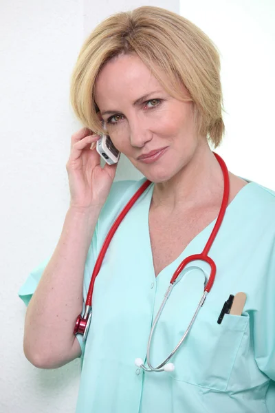 Больничный врач с помощью мобильного телефона — стоковое фото