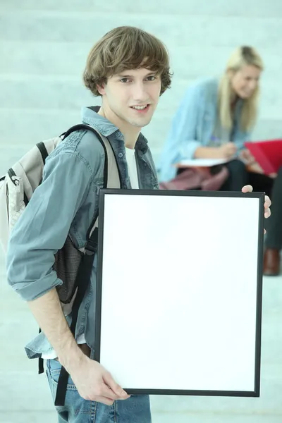 Estudante segurando placa branca — Fotografia de Stock