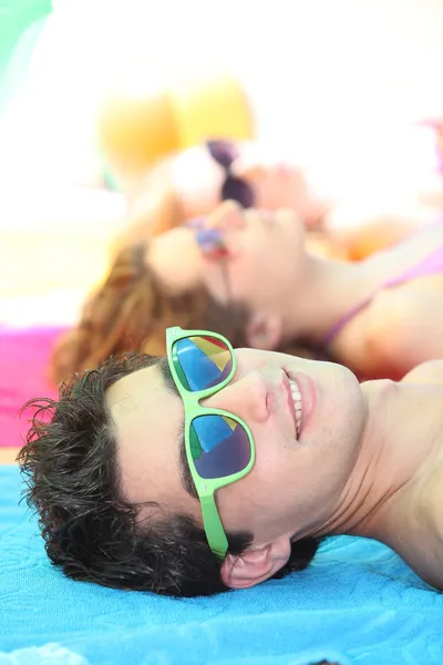 Tieners liggend op het strand — Stockfoto
