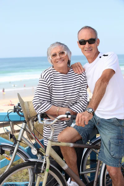 Casal sênior andar de bicicleta na praia — Fotografia de Stock