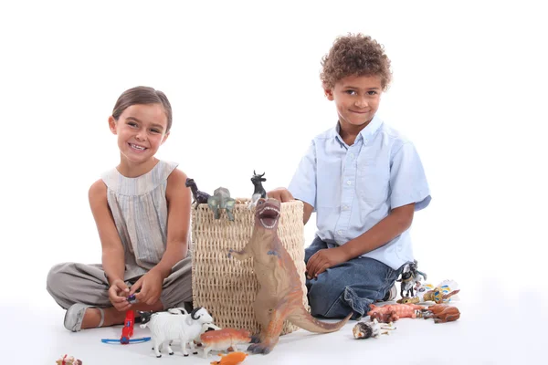 Children playing with plastic toy figurines — Stock Photo, Image
