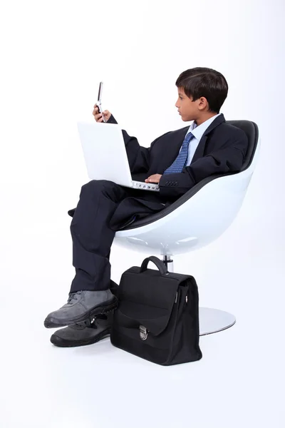 Kis fiú öltözött üzleti ember dolgozik — Stock Fotó