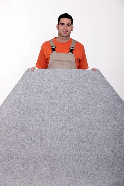 Muž s srolovaný koberec — Stock fotografie