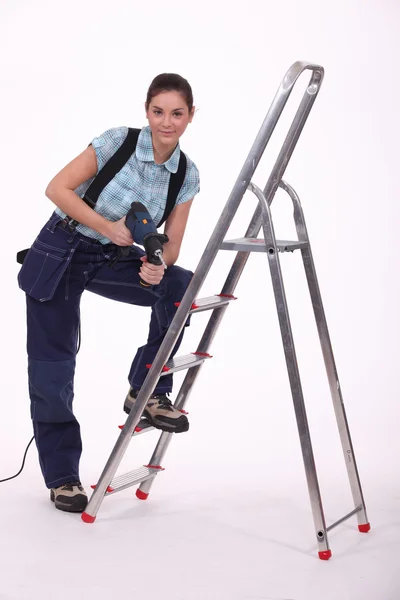 Artesão feminina com broca e escada — Fotografia de Stock