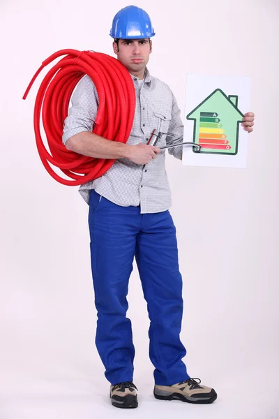Eletricista segurando cartaz de classificação de energia — Fotografia de Stock