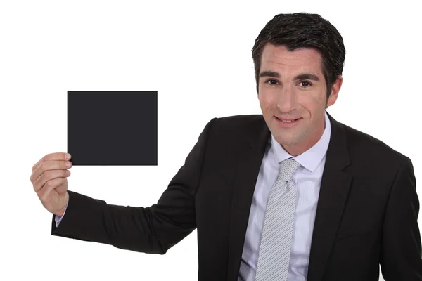 Uomo in giacca e cravatta che mostra carta nera — Foto Stock