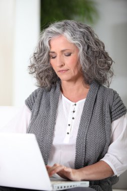Woman working on her laptop clipart