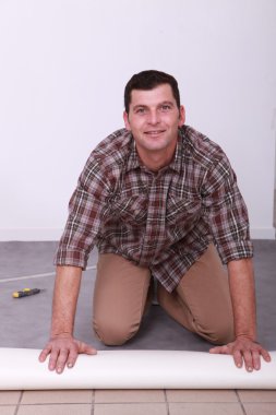 Man unrolling carpet clipart