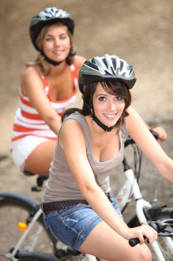 Two girls riding bikes clipart