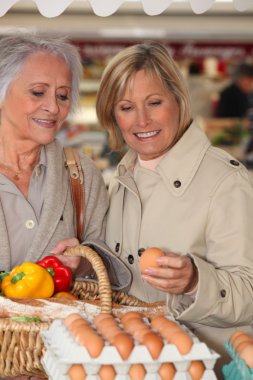 Mother and daughter shopping at the market together clipart