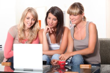 Young women watching a film on a laptop clipart