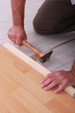 Handyman laying floorboards clipart