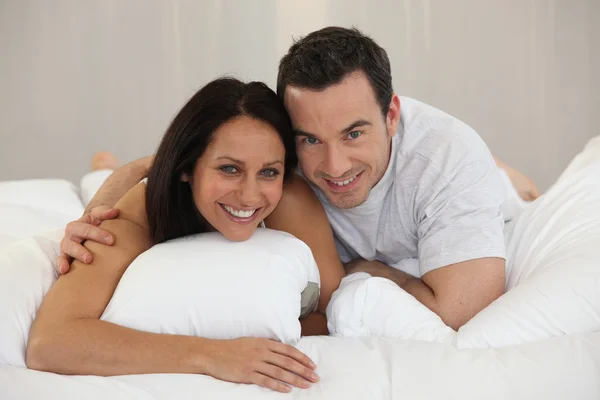 Paar liggend op een bed — Stockfoto