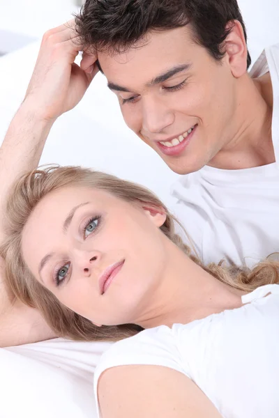 Молодая женщина и молодой человек лежат на диване — стоковое фото