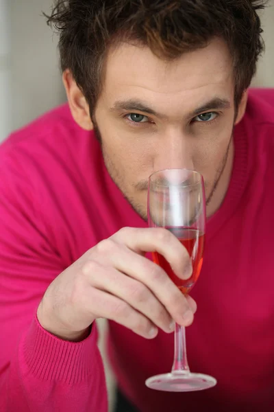 Νεαρός άνδρας μυρίζοντας ένα ποτήρι ροζέ κρασί — Φωτογραφία Αρχείου