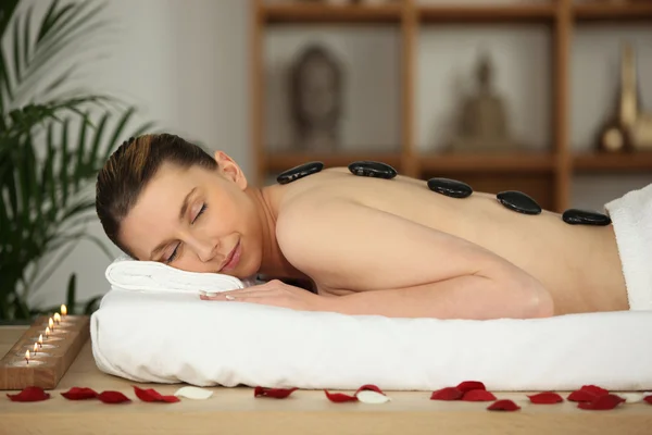 Femme couchée ayant des pierres chaudes massage — Photo