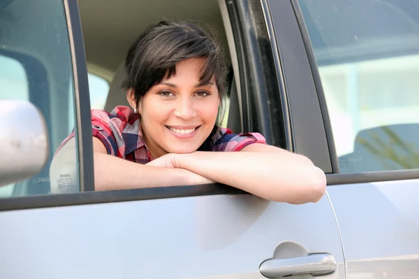 Junge Frau lehnt sich aus dem Fenster eines Autos — Stockfoto